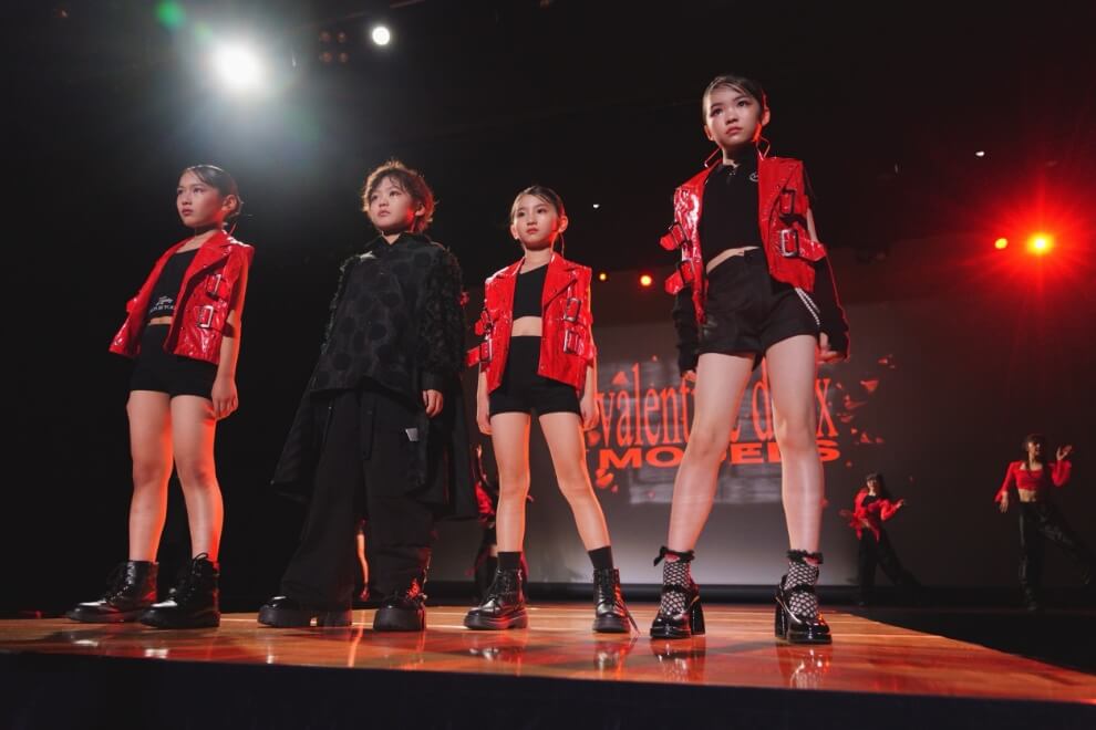 SHOW：赤と黒の衣装を着た子供たちがステージに立っている様子