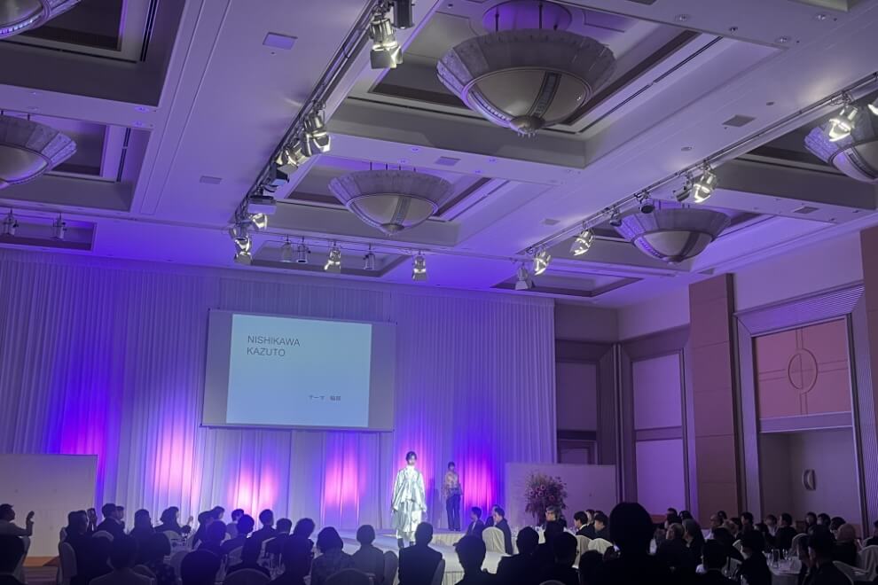 SHOW：紫の照明が灯る会場でファッションショーが行われている様子